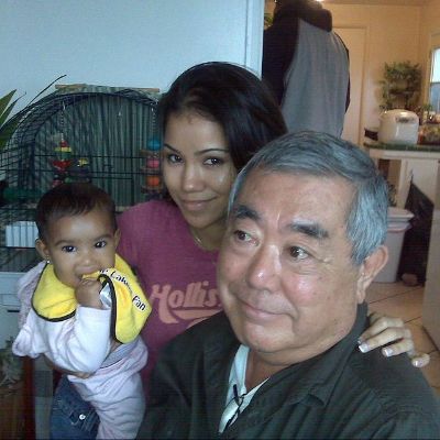 Christina Yamamoto is holding the young Jhené Aiko as Tadashi Yamamoto is distracted by something.